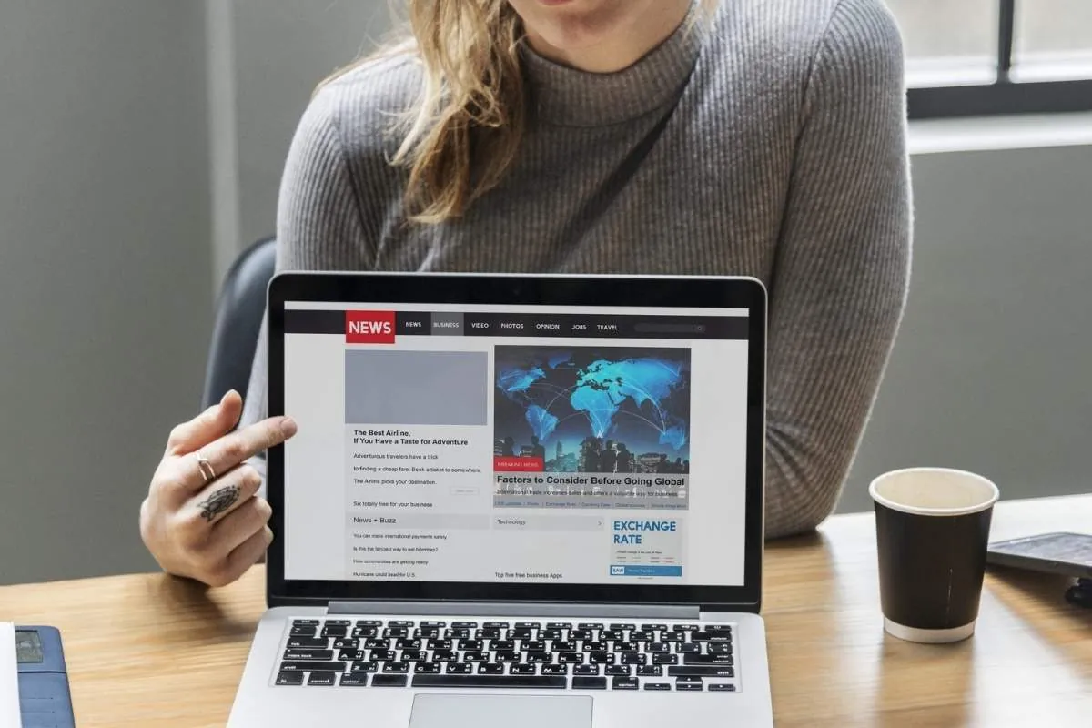 Blond woman pointing laptop screen