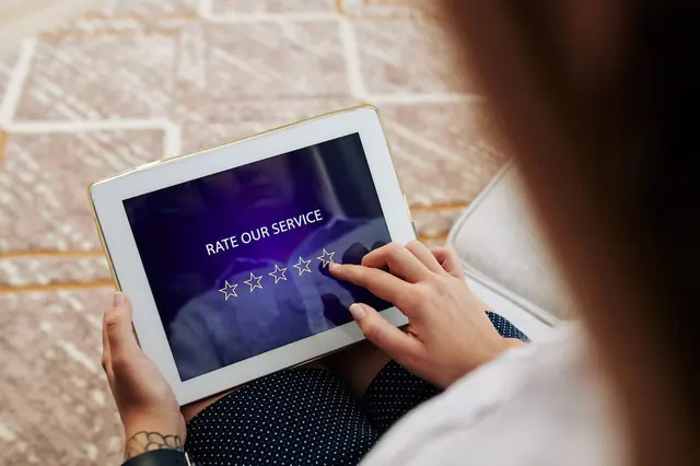 Someone using a review link to post a review of a service on a tablet