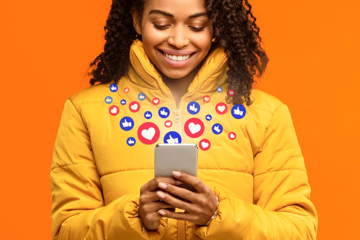 Leveraging Social Media Strategies to Boost Website Traffic 1 96584606 happy black woman holding smartphone with like buttons yellow background